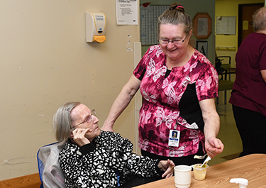 Val assists a resident with their meal during a practicum placement.