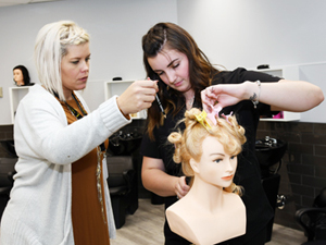 Angie Rowsell, instructor, School of Health and Wellness, guides a student through a hairstyling lab at the Lloydminster campus.