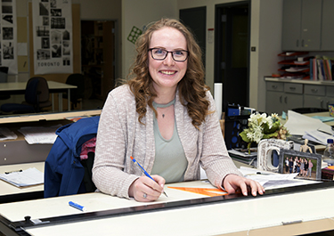 Courtney at her desk in one of Lakeland's interior design learning spaces.