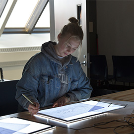Student working on a drawing board