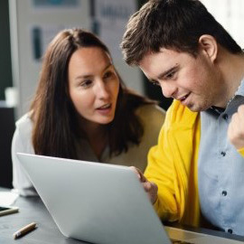 Student and instructor working on a laptop