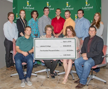 Judy Sweet (front row, second from the left) presents Josie Van Lent, dean of Lakeland’s School of Agricultural Sciences, and Geoff Brown, associate dean, with a donation to help grow Lakeland's farm.