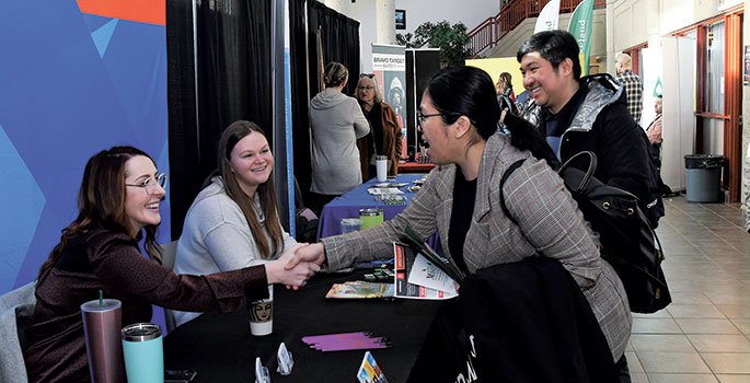 Student shaking hands with an employer vendor at the career fair