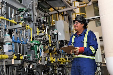 An energy student in personal protective equipment in functioning steam lab.