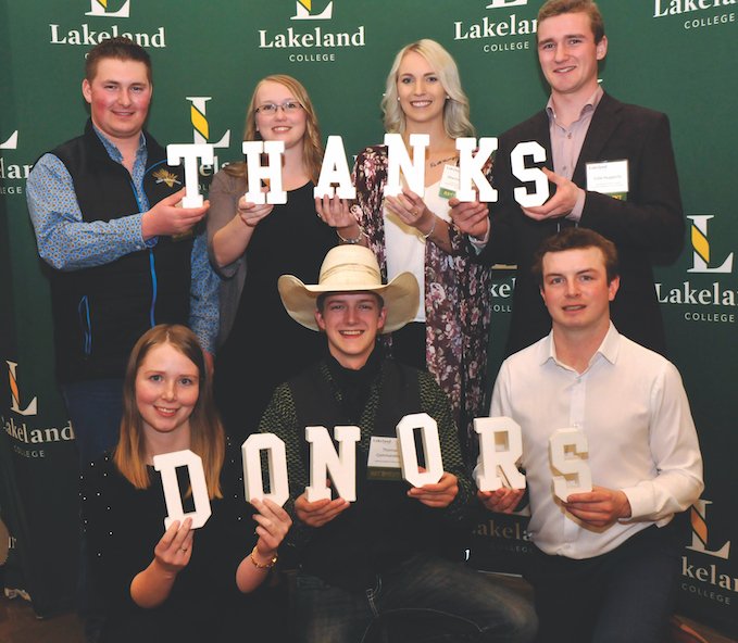 Students stand holding letters, spelling out Thanks Donors
