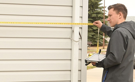 Person measuring length of home with tablet in hand