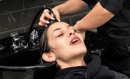student stylist washing client's hair