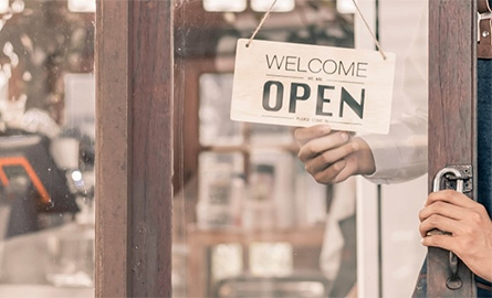 Small business owner flipping open sign