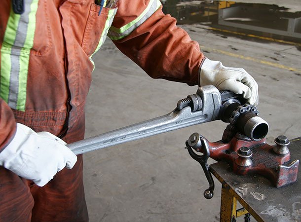 Worker using wrench to tighten a part