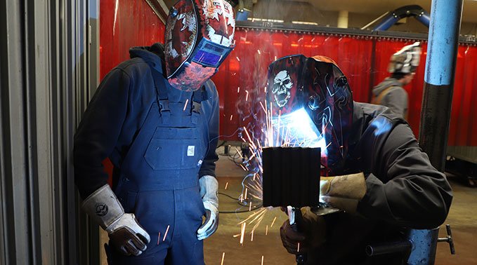 Brandon mentoring a student welder