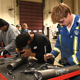 Apprentice auto technicians practicing in the shop
