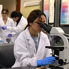 Student working in a lab using a microscope