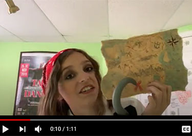In a screenshot from a video, Lakeland College student Tia Pavo is dressed as a pirate as she helps children solve math problems to find a treasure.
