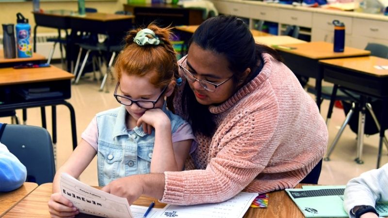 Student helps a youth with school work