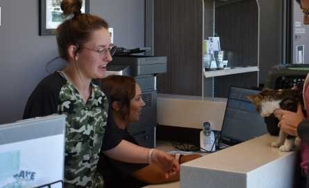 two students at reception desk of Animal Health Clinic