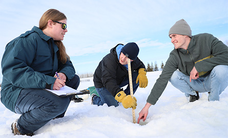 Students measuring ice samples at the trout pond