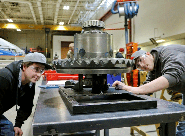 Two students inspecting an automotive part