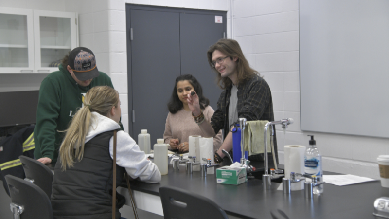 Conner Coleman talks with his classmates in a classroom.
