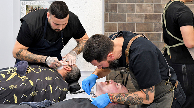 Barber students Kenneth Badger and Clark Drury shave moustaches and beards in part of a Movember fundraiser.