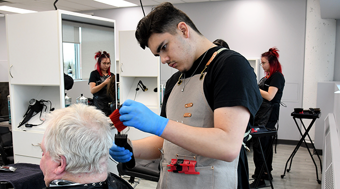 Barber student Kenneth Badger services a client at the student-led hair salon on the Lloydminster campus.