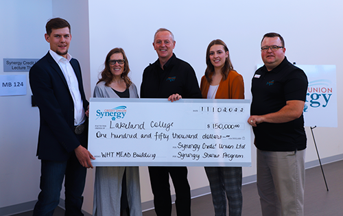 Agribusiness student Pieter van Zyl, Dr. Alice Wainwright-Stewart, Lakeland President & CEO, Glenn Stang, Synergy Credit Union CEO, Agribusiness student Avery Bayda and Brent Baier, vice chair of Synergy Credit Union's Board of Directors outside the WHT Mead Building's Synergy Credit Union Lecture Theatre on the Vermilion campus.