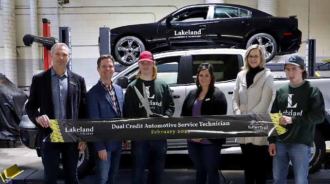 Student and representatives from Lakeland College and Buffalo Trails School Division hold a ribbon that says Dual Credit Automotive Serive Technician