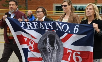 Lakeland president and Indigenous guests with Treaty 6 flag