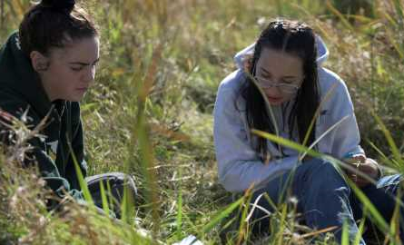 2 students identifying upland and wetland plants